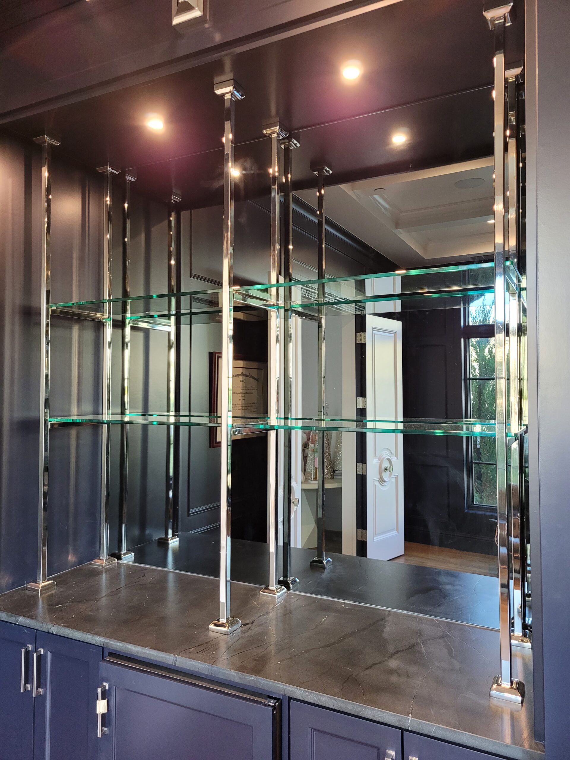 Custom steel fabricated glass shelving unit with polished nickel coating